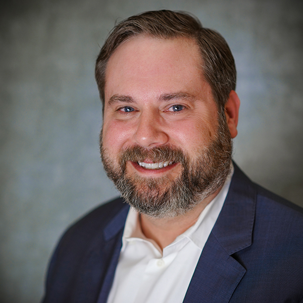 A man with a beard and suit jacket