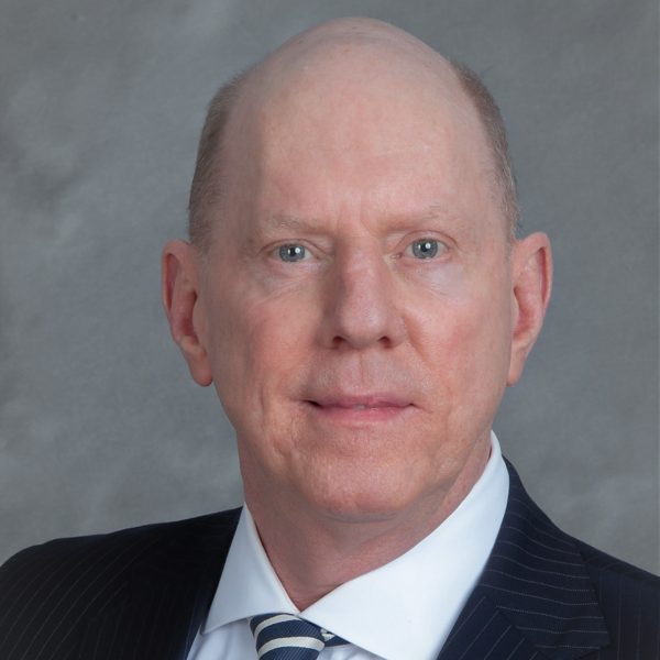 A man in suit and tie with bald head.